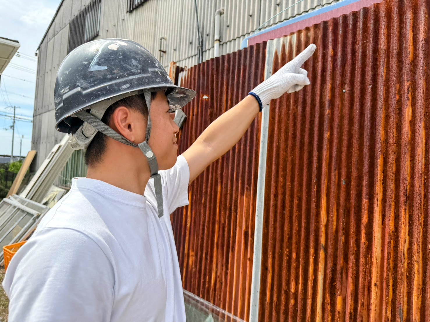 金属外壁の劣化状況を現地で点検する職人